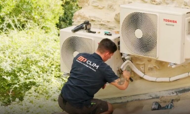 echnicien MP Clim, installateur de climatisation à Orange, raccordant deux unités extérieures Toshiba Inverter sur façade en pierre.